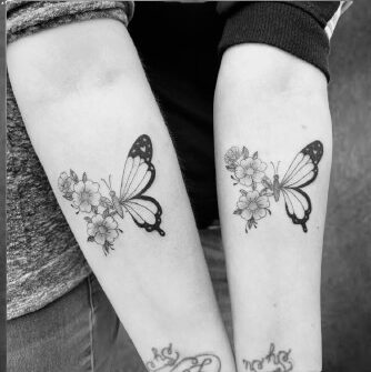 Filigrane Schmetterling-Tattoos mit Blumen auf beiden Unterarmen, gestochen im Black Dot Tattoo Studio Besigheim.