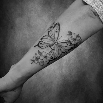 Schmetterling-Tattoo mit Blumen auf dem Unterarm, gestochen im Black Dot Tattoo Studio Besigheim.