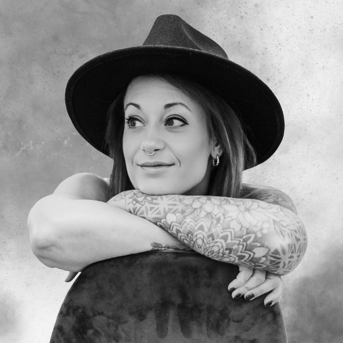 Porträt von tätowierter sarah.dot.ink mit Hut und Mandala-Arm-Tattoo, aufgenommen im Black Dot Tattoo Studio Besigheim.